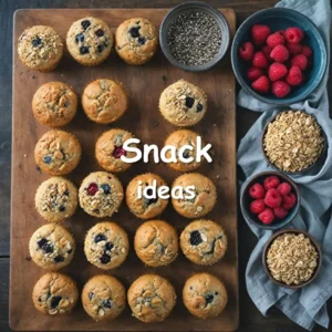 An assortment of healthy snacks including quinoa bites, almond flour muffins, chia seeds, fresh fruits, and nuts on a rustic wooden table.