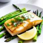 A beautifully plated fish dish with garlic butter asparagus, lemon wedges, and fresh herbs, perfect for a fish food recipe.